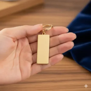 Showing the practical size of the gold keychain held in a person's hand for easy comparison.