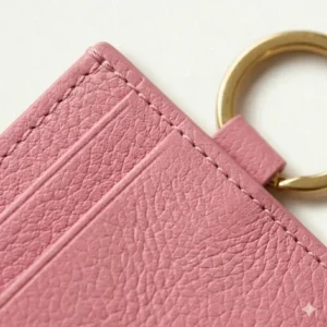 Close-up detail of the pink vegan leather texture on durable card cases with keychain.